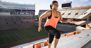 Woman running up stadium steps for exercise.