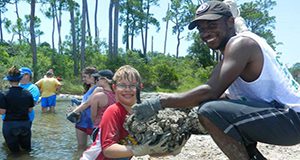 youth and adult volunteers placing a living shoreline of oysters in mesh bags