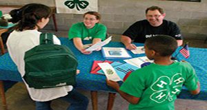 4-H youth and volunteers at a table with 4-H materials
