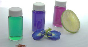 photo of three vials of translucent colored liquid demonstrating coloration by BPFE extract at normal pH (blue), lowered pH (green), and raised pH (purple)