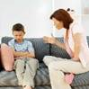 A mom talking to her son on a couch.