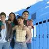 A group of teens posing together in a school hallway.