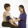 A nurse taking a woman's blood pressure.
