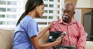 A nurse measuring an older man's blood pressure