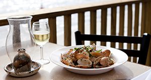 a beach-side  table setting with seafood and wine